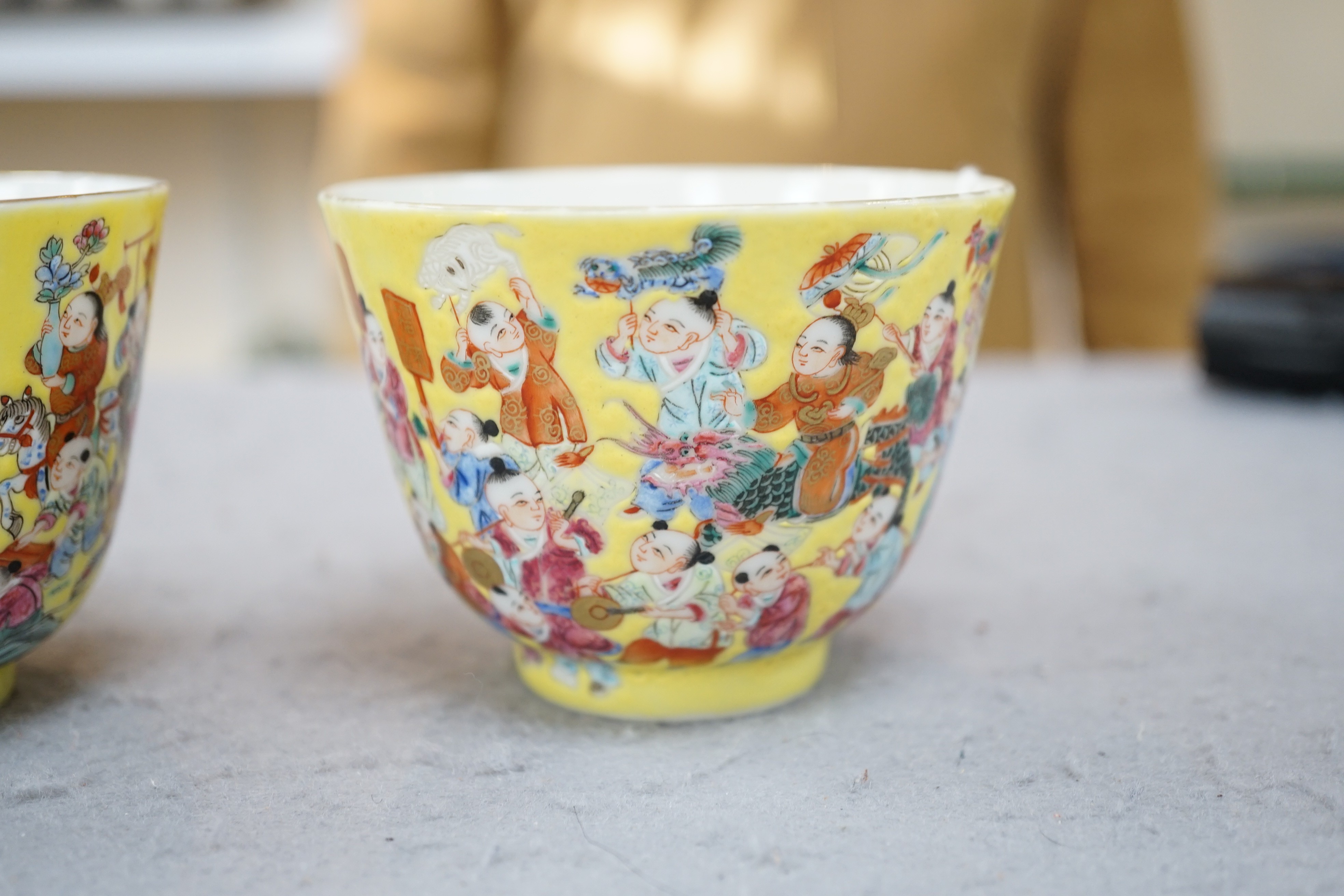 A pair of Chinese yellow ground 'Hundred Boys’ cups, 19th century, 6.5cm high 8.5cm diameter